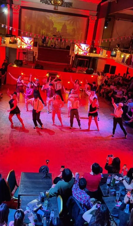 Alumnos de Kultura de Baile presentando una coreografía en la pista, con luces rojas y público alrededor